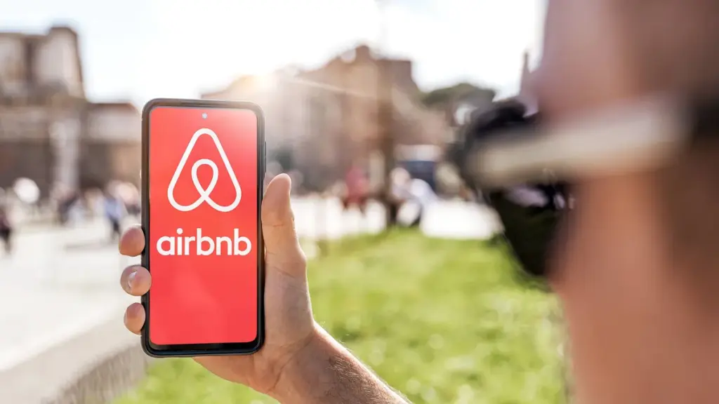 2-april-2023-a-young-man-holds-a-smartphone-with-the-airbnb-app-and-logs-in-for-a-simple-and-conveni.webp
