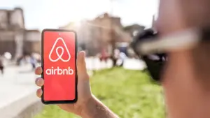 2-april-2023-a-young-man-holds-a-smartphone-with-the-airbnb-app-and-logs-in-for-a-simple-and-conveni.webp
