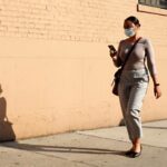 A woman wearing a protective mask walking