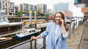 eine-frau-steht-mit-handy-im-hamburger-hafen-und-telefoniert-symbolbild-die-telekom-hat-den-connect.webp