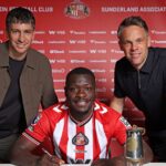 SUNDERLAND, ENGLAND - SEPTEMBER 2: Brian Bobbery poses for pictures with Director of Football Florent Ghisolfi (L) and Sporting Director Krisjaan Speakman (R) after signing a five year deal for Sunderland at The Academy of Light on September 2, 2025 in Sunderland, England.  (Photo by Ian Horrocks/Sunderland AFC via Getty Images)